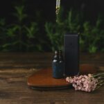 CBD oil bottle with dropper and flowers on table.